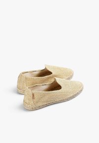 Espadriller i naturligt vævet jute-materiale, beige farve, slip-on design, flad sål og kontrastsyning omkring kanterne.