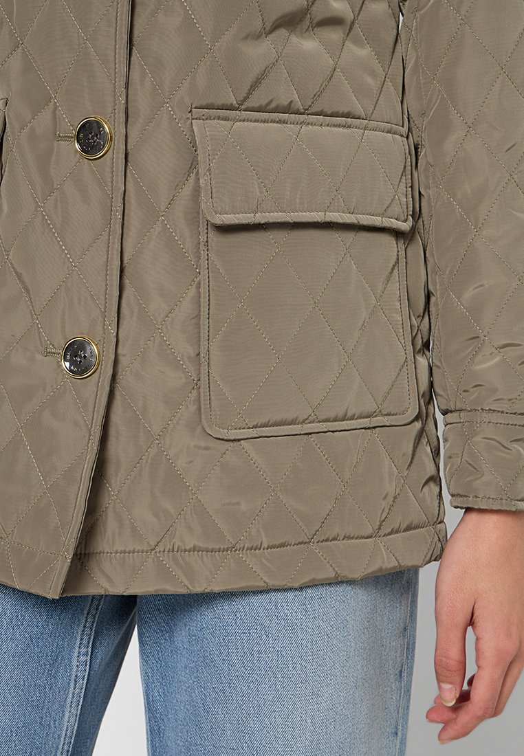 Quilted olivgrüne Jacke mit zwei goldfarbenen Knöpfen, einer aufgesetzten Tasche und glatter Textur mit Rautenmuster-Steppung.