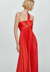Abito maxi rosso plissettato con design a spalla unica e dettaglio a chiave sul décolleté, realizzato in materiale leggero. Texture liscia e fluida.