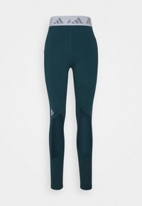 Vihreät urheiluhousut, joissa on verkkoleikkauksen suunnittelu, kontrastivärinen harmaa joustava vyötärönauha, jossa on brändin logo; valmistettu joustavasta materiaalista.