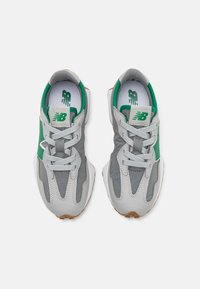 Zapatillas deportivas grises y verdes con una parte superior texturizada, diseño de cordones y suelas de goma. Presentan un logo en la lengua y perforaciones distintivas.