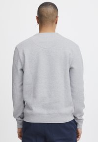 Grijze crewneck sweatshirt met lange mouwen en geribbelde zoom, gemaakt van een gladde, zachte stof. Kenmerkt zich door een ronde detail aan de achterkant van de halslijn.
