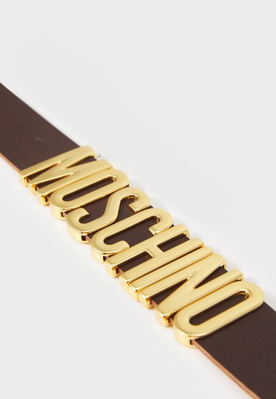 Hnedý kožený opasok s veľkými zlatými písmenami, ktoré nápadne tvoria slovo "MOSCHINO" na prednej strane, lesklý povrch s textúrovanými akcentmi.