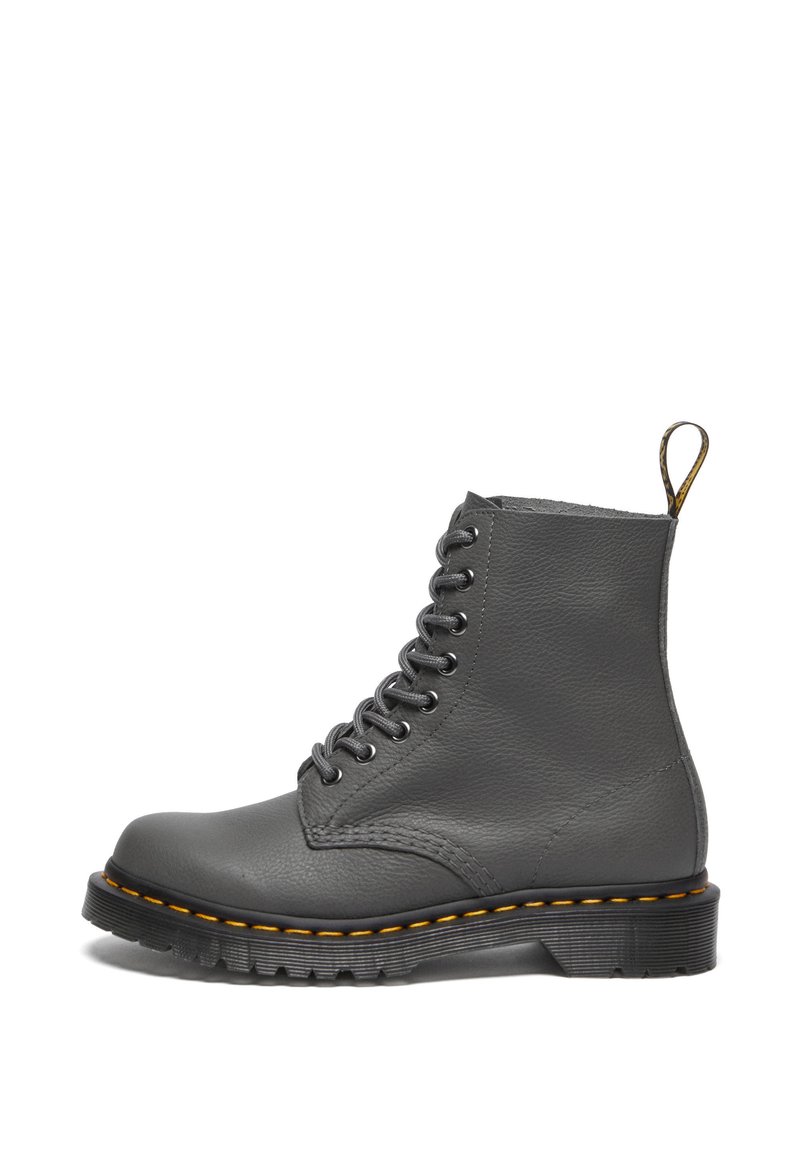 Bota de cuero gris con cordones, punta redonda, costuras amarillas, superficie texturizada, asa en la parte trasera y suela de goma negra gruesa.
