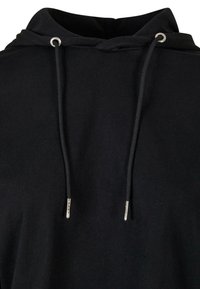 Sweat à capuche noir avec cordons attachés et œillets métalliques au niveau du col sur un fond uni.