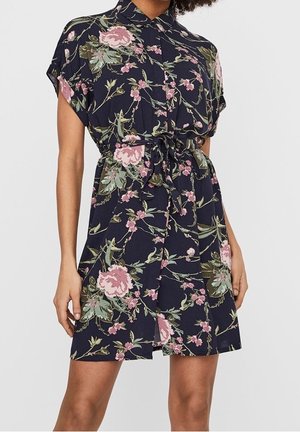 Krótkia sukienka z krótkim rękawem w granatowym kolorze, z kołnierzykiem, taliowaną talią oraz wzorem różowych i zielonych kwiatów. Lekka tkanina, luźny krój.