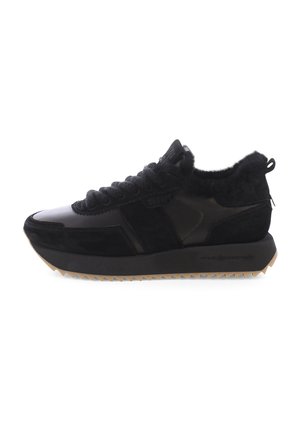 Des baskets noires en cuir et en daim, avec un col duveteux, une tige texturée, et une semelle épaisse et crantée avec une semelle en gomme.