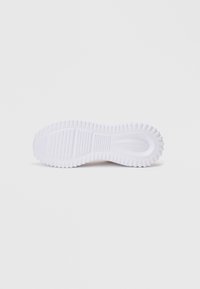 Άσπρη σόλα αθλητικού παπουτσιού από καουτσούκ με υφή και οριζόντιες ραβδώσεις. Ο σχεδιασμός διαθέτει στρογγυλεμένη μορφή και έντονα χαρακτηριστικά πρόσφυσης.