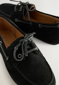 Zwarte suède boot schoenen met een gladde textuur, leren veters, zilveren oogjes en een bruine binnenvoering. Bevat een gestikt ontwerp.