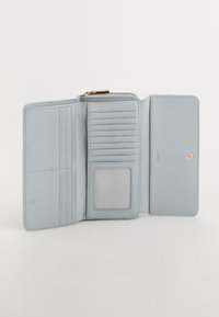 Billetera de cuero azul claro con múltiples ranuras para tarjetas, una ventana transparente para identificación y un compartimento con cremallera. Textura suave y diseño limpio.