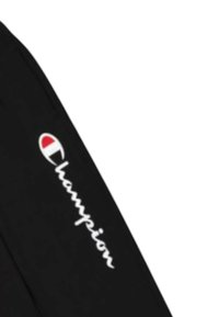 Giacca sportiva nera con logo testuale bianco "Champion", caratterizzata da un emblema rosso e bianco. Tessuto morbido, vestibilità classica, maniche lunghe.