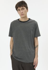 Black and gray striped t-shirt with short sleeves and a black crew neck. Fabric appears soft with a relaxed fit. No patterns or accents.