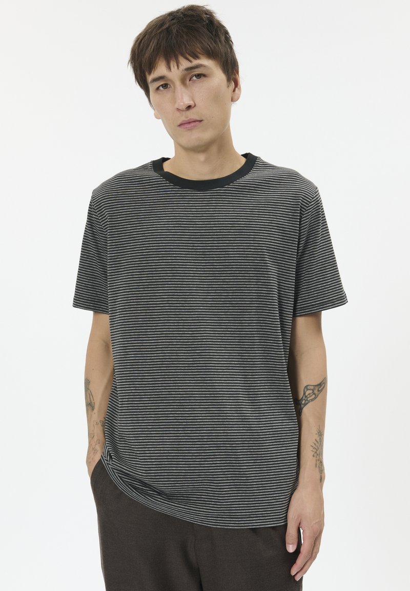 Black and gray striped t-shirt with short sleeves and a black crew neck. Fabric appears soft with a relaxed fit. No patterns or accents.