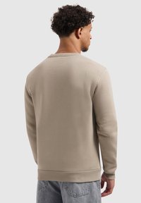 Beige sweater met een ronde hals en ribgebreide boorden, met een gladde textuur. De achterkant heeft een eenvoudige, ongecompliceerde uitstraling.
