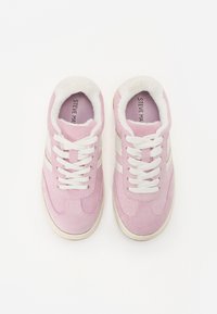 Sneaker in camoscio rosa con lacci bianchi e strisce laterali, dotate di una morbida fodera in pelliccia e di una suola in gomma elevata di un leggero colore avorio.