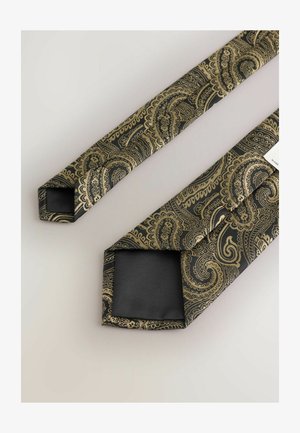 Schleife in Schwarz mit goldenen Paisleymuster, aus glattem Seidenmaterial und mit schrägen Enden. Ein Ende zeigt eine schwarze Fütterung mit einem Etikett.