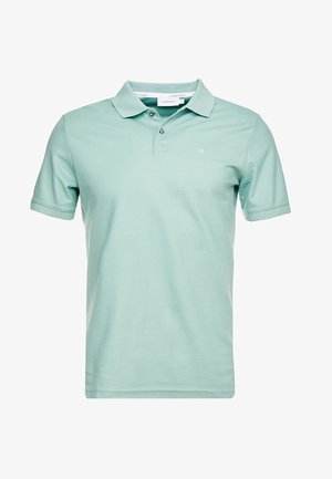 Polo verde chiaro in morbido cotone, con colletto classico, maniche corte, patta con due bottoni e un logo discreto sul petto.