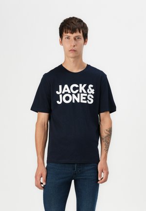 Donkerblauwe katoenen t-shirt met korte mouwen, voorzien van grote witte "JACK & JONES" logo-tekst op de voorkant. Klassieke ronde hals ontwerp.