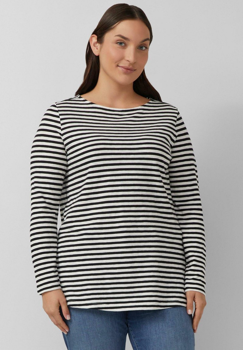 Zwart-wit gestreepte longsleeve met een ronde hals, gemaakt van zachte stof, gecombineerd met blauwe jeans. Eenvoudig, casual ontwerp.