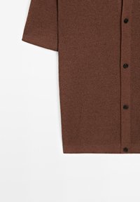 Brown ribbed knit garment with black buttons, short sleeve visible, photographed on a white background. No people present.