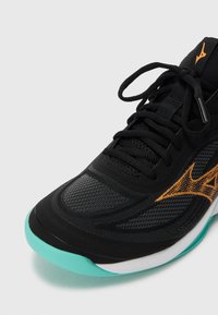 Black athletic shoe featuring a breathable mesh upper with an orange accent. A teal sole adds contrast, enhancing the sleek, modern design.