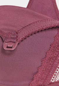 Mauve-BH mit glattem Stofftextur, Spitzenakzenten, verstellbarem Träger und Verschluss mit Haken; verfügt über eine gewellte Kantendetail.