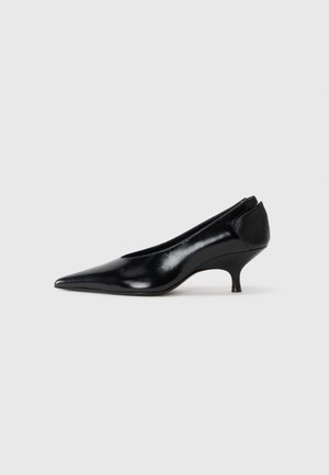 Black leather pump with a pointed toe, low heel, sleek design, and smooth texture. Features a slip-on style with no visible hardware.