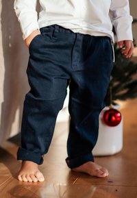 Laivansiniset puuvillahousut rentoa istuvuutta, joissa on sileä pinta, käänteiset lahkeet ja sivutaskut, käytetään paljain jaloin.