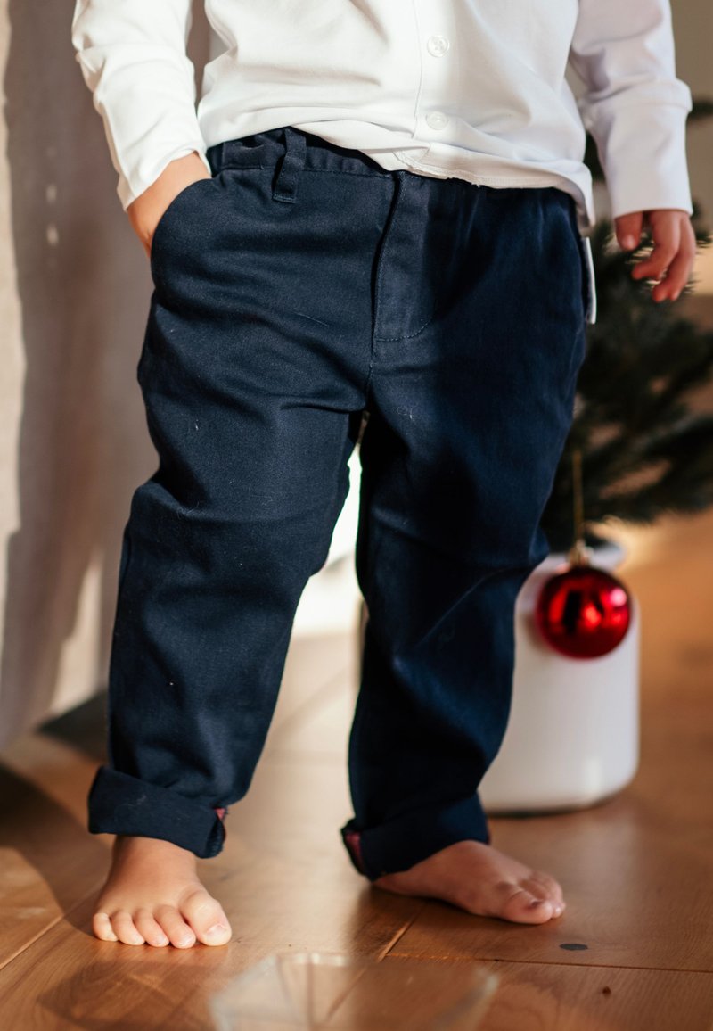 Laivansiniset puuvillahousut rentoa istuvuutta, joissa on sileä pinta, käänteiset lahkeet ja sivutaskut, käytetään paljain jaloin.