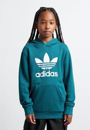 Felpa teal con tasca a marsupio, presenta un grande logo Adidas bianco e tre strisce orizzontali. Tessuto morbido con vestibilità rilassata.
