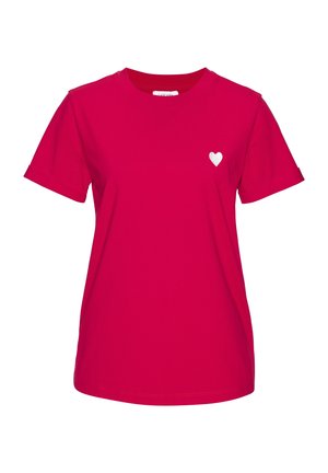Knallpinker Kurzarm-T-Shirt mit kleinem weißem Herz-Emblem auf der linken Brust, mit rundem Ausschnitt und hochgekrempelten Ärmeln.