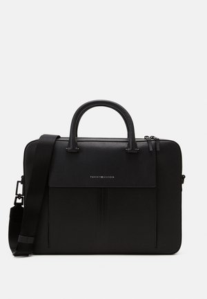 Black textured leather briefcase with dual handles, detachable shoulder strap, front flap pocket, and Tommy Hilfiger logo on front.