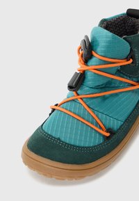 Scarpa da esterno in tonalità teal e verde scuro con una parte superiore testurizzata, lacci arancioni e suola in gomma. Presenta una chiusura a strappo e materiali sovrapposti.