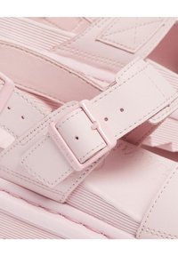 Sandali in pelle rosa con cinturini larghi, dotati di una fibbia rettangolare, superficie testurizzata e suola spessa e rigata. Finitura morbida, design leggero.