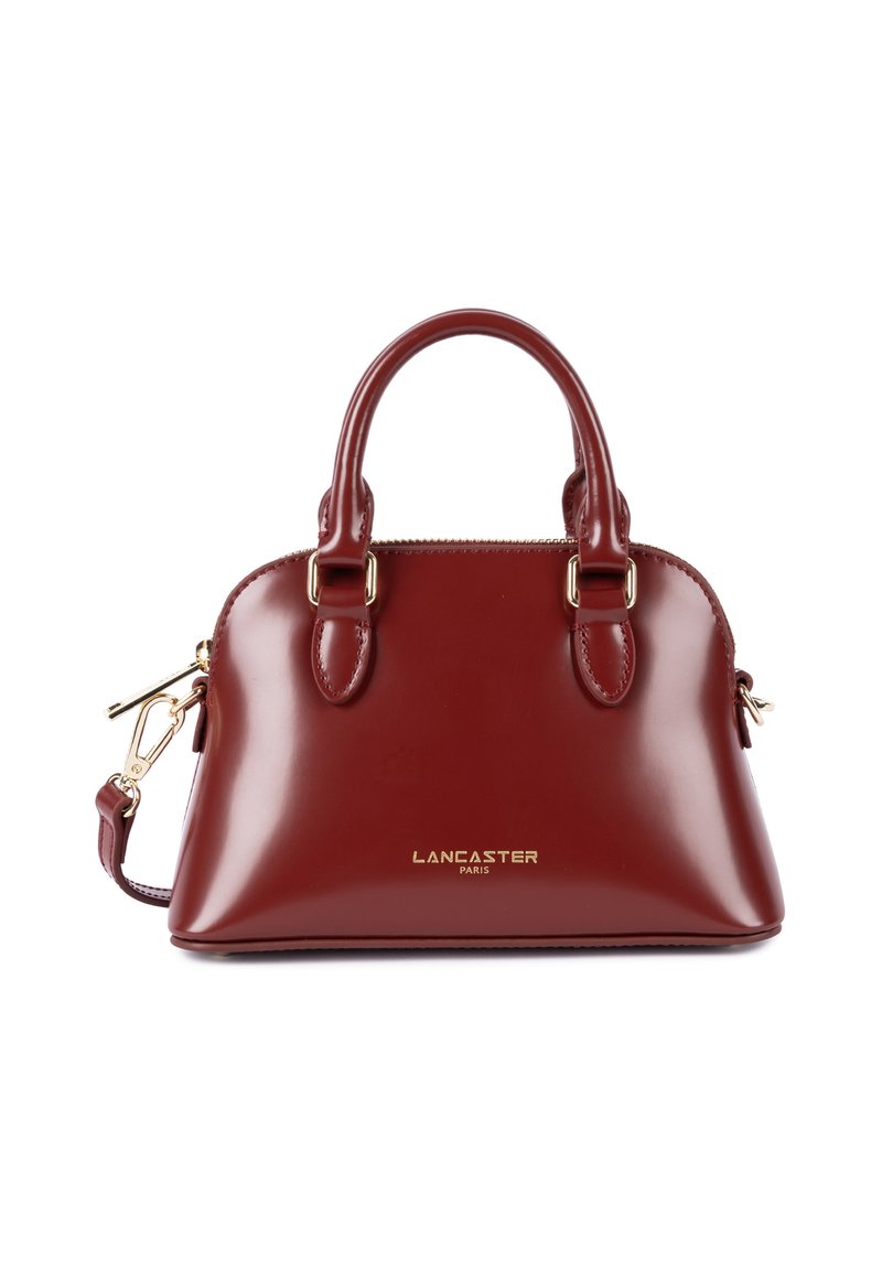 Sac à main en cuir bordeaux avec une finition brillante, un dessus arrondi, des poignées doubles et une bandoulière amovible. Détails en métal doré et marque.