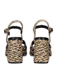 Zapatillas de esparto tejidas en negro y beige con una textura trenzada, abertura en la parte posterior, tira en el tobillo y diseño de tacón bloque.