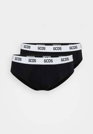 Deux paires de slips noirs en coton avec des ceintures élastiques blanches arborant le texte "GCDS" en noir. Texture lisse, design taille basse.