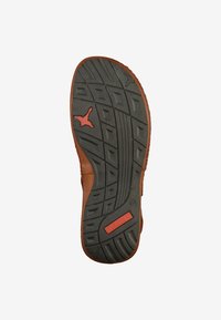Brown shoe sole with a textured black rubber surface. Features a red logo and various tread patterns for grip and stability.