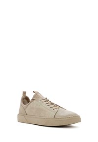 Sneaker beige in suede con una texture liscia, punta rotonda e allacciatura frontale. Presentano un tassello sul tallone e una suola piatta in gomma.