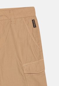 Beige cargo šortky s rovný střihem, několika kapsami a jemnými švy. Odolná látka s měkkou texturou.