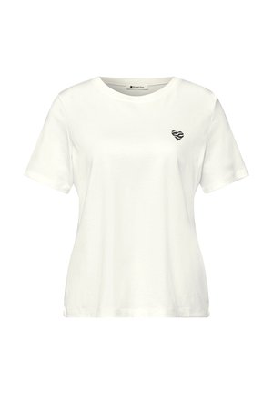 Camiseta blanca de manga corta con cuello redondo y pequeño estampado de cebra en forma de corazón negro en el pecho izquierdo.