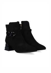 Botas de ante negras hasta el tobillo con punteras afiladas, cremallera lateral y un exclusivo tacón de bloque con patrón. Presenta un detalle de tira de acento negra.