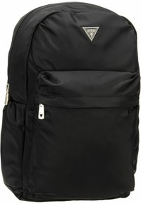 Mochila negra de nailon con un logo metálico triangular, un bolsillo frontal con cremallera, textura suave y panel trasero acolchado para mayor comodidad.