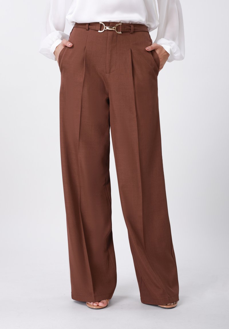 Pantalon plissé marron à taille haute, confectionné dans un tissu lisse. Il est doté d'une ceinture à anneau D doré et de poches latérales pour plus de détails.