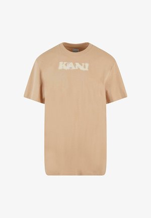 Beżowy t-shirt bawełniany z krótkimi rękawami, okrągłym dekoltem i graficznym nadrukiem "KANI" w jasnych kolorach na środku. Miękka tekstura, swobodny fason.