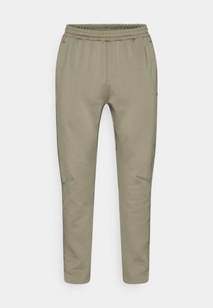 Φωτεινό ελιάς πράσινο παντελόνι jogger με κορδόνι στη μέση, στενόμακρα πόδια, πλαϊνές τσέπες με φερμουάρ και λείο, ελαστικό ύφασμα.