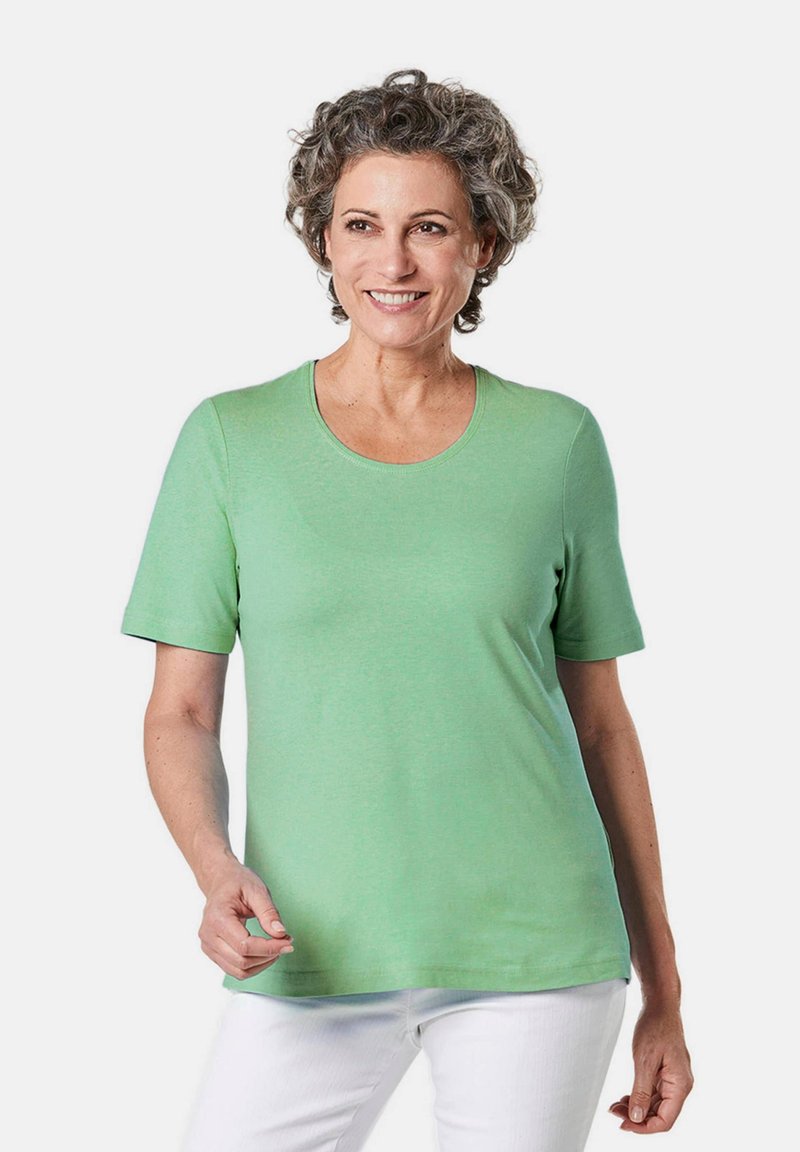 Korte mouwen, ronde hals t-shirt in lichtgroene katoen. Heeft een soepele textuur en een casual pasvorm, gecombineerd met witte broeken.