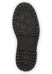 Semelle de chaussure en caoutchouc noir avec un motif de bande de roulement profond, présentant des formes géométriques en relief et une zone marquée portant la marque "Marc O'Polo." Taille 37.