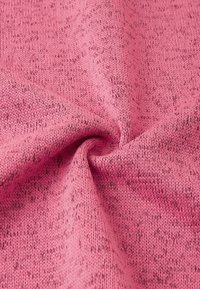 Rosa gestrickter Stoff mit einer strukturierten Oberfläche, der ein dezentes gepunktetes Muster aufweist und einen weichen, flexiblen Fall hat.