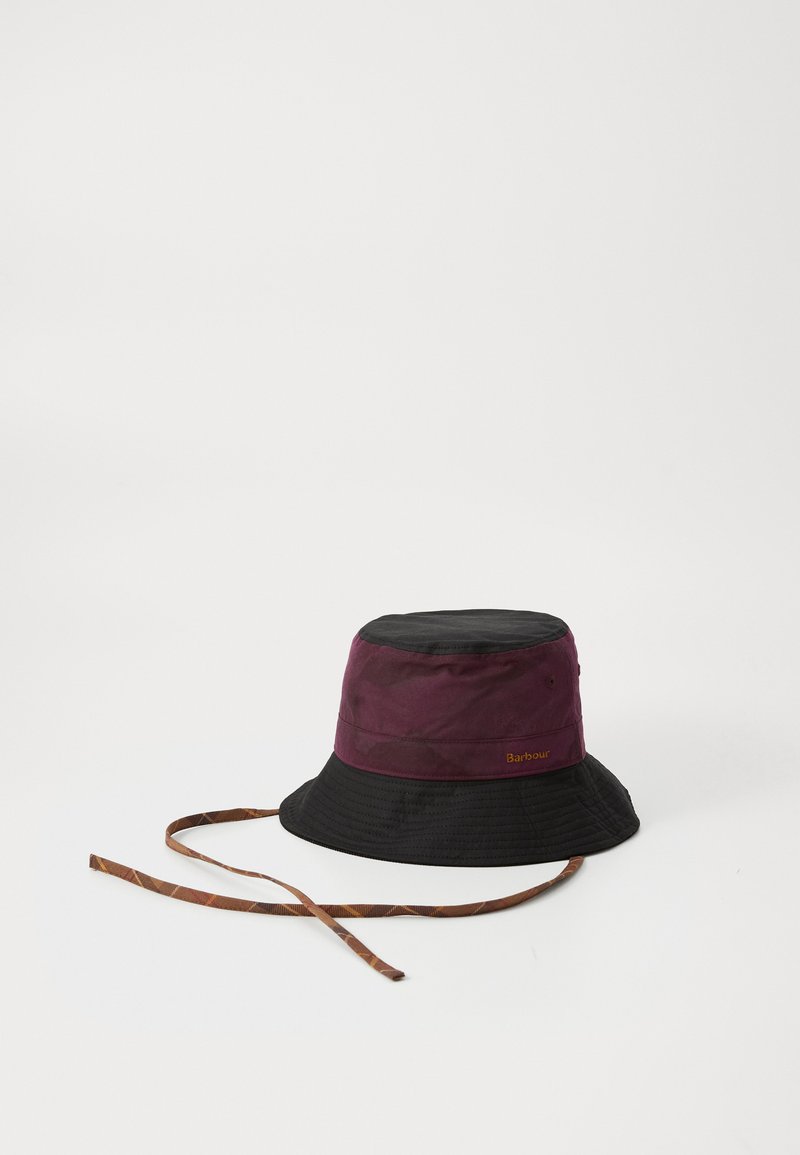 Chapeau seau bicolore avec un dessus bordeaux et un bord noir, fabriqué en tissu durable avec une finition texturée et une sangle marron à motifs.